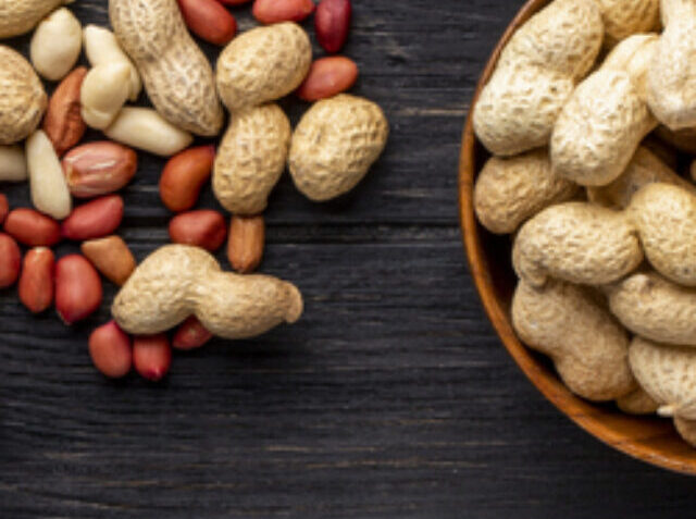 cropped-top-view-unshelled-peanuts-bowl-with-peeled-black-wooden-table1.jpg